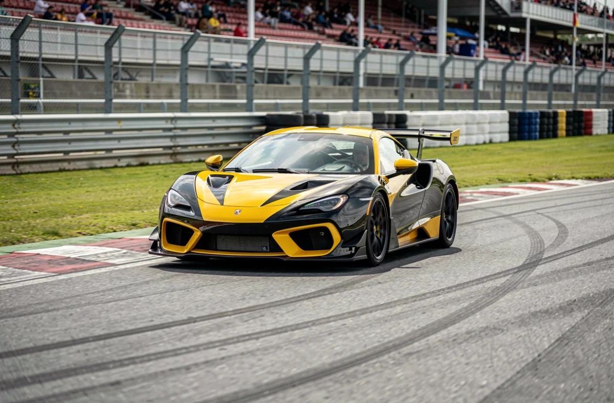 Voiture de sport en pleine négociation d'un virage sur circuit automobile lors d'un stage de pilotage